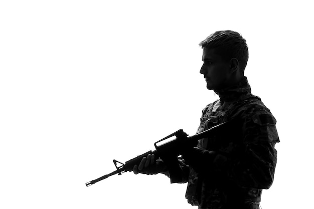 Бесплатное фото Солдатский силуэт армии крутой красивый серьезный сильный солдат в форме смотрит вниз