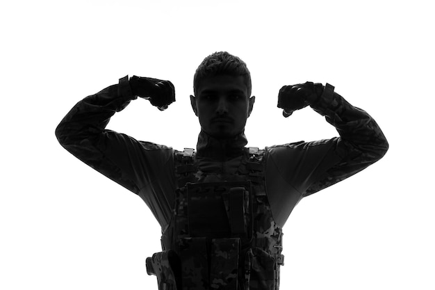 Soldato della siluetta del soldato serio bello forte duro dell'esercito soldato in uniforme che mostra la forza