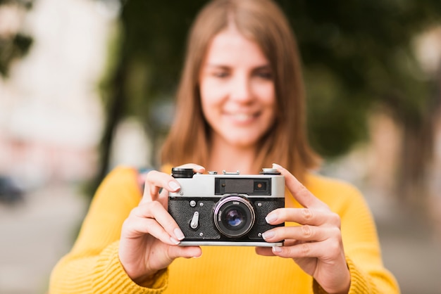 Free photo solo travelling woman holding camera