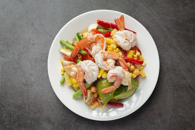 Som Tum with Corn and Shrimp, served with rice noodles and green salad Decorated with Thai food ingredients.