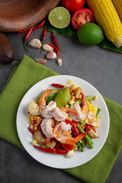 Foto gratuita som tum con mais e gamberetti, servito con spaghetti di riso e insalata verde decorato con ingredienti alimentari tailandesi.