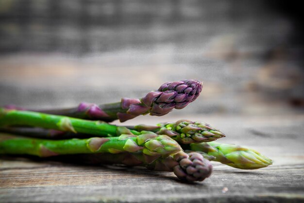 Free photo some asparagus on wooden background, close-up.