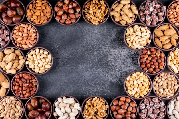 Free photo some of assorted nuts and dried fruits with pecan, pistachios, almond, peanut, in a mini different bowls