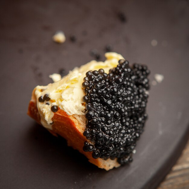 어두운 배경, 높은 각도보기에 빵에 버터와 함께 일부 검은 캐 비어.