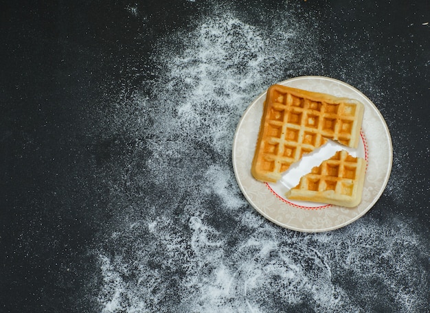 Некоторый сломанный waffle в плите на темноте, взгляд сверху.