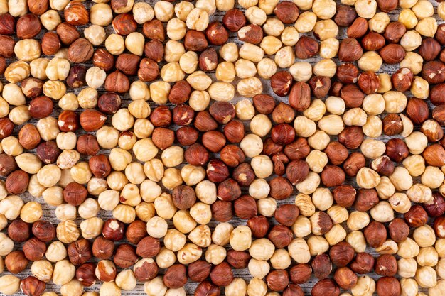 Some of cleaned hazelnuts on white wooden table, flat lay.