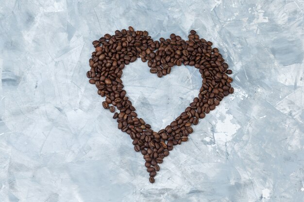 Some coffee beans on grey plaster background, flat lay.