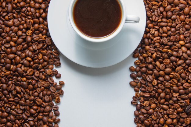 Some a cup of coffee on with coffee beans on background, top view. space for text