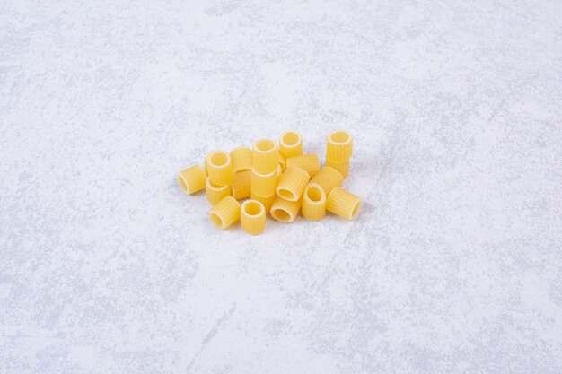 Some of fresh raw macaroni on white surface