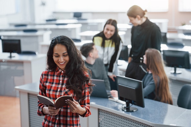 Some interesting information. Group of young people in casual clothes working in the modern office