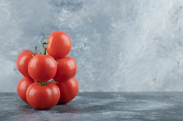 Some of juicy tomatoes on gray .