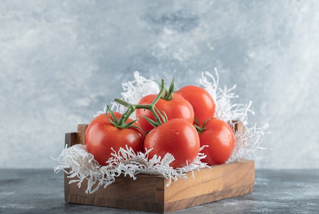some of juicy tomatoes on wooden basket .