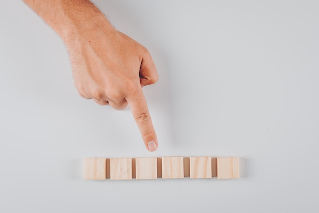 Some man pointing to wooden blocks on white