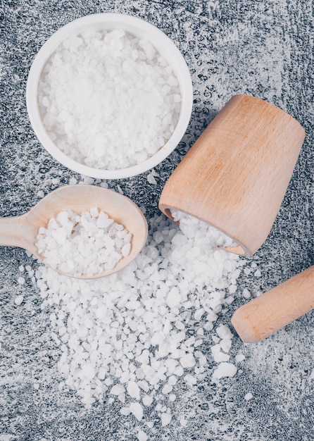 Some sea salt with rolling pin in bowls and spoon