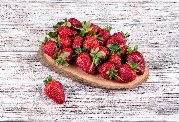 Some strawberries on light wooden table
