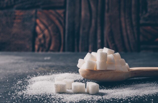 Some white sugar in a spoon, side view.