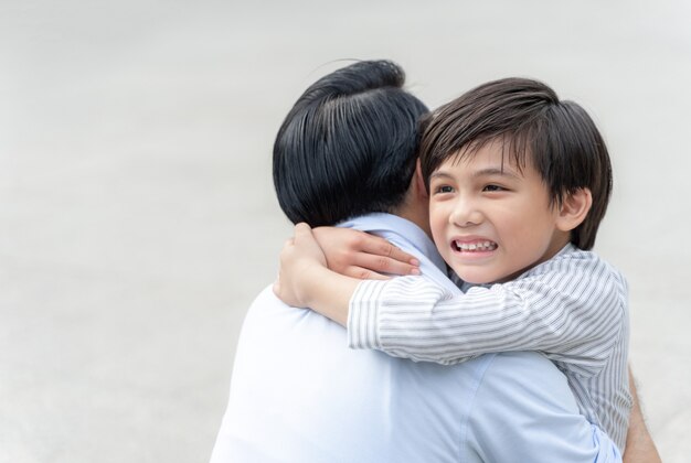 息子は彼の父を抱きしめて幸せな、独身のお父さんと息子の幸せアジアの家族の概念を満たします