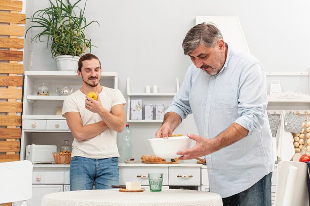 Free photo son looking at father preparing dinner