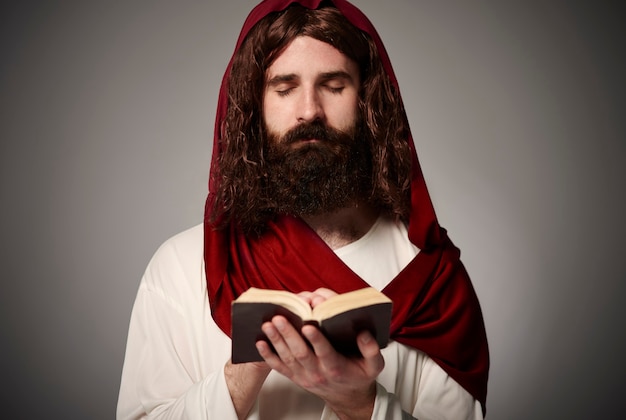 Бесплатное фото Сын божий молится с библией