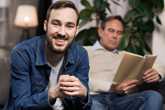 Son posing while father reading