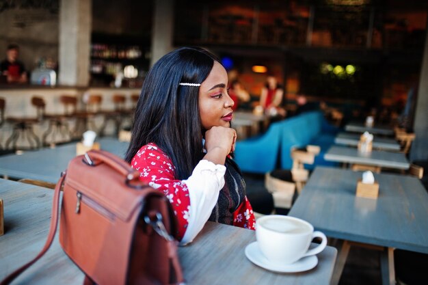 Солидная молодая африканская американка в элегантной повседневной одежде в кафе
