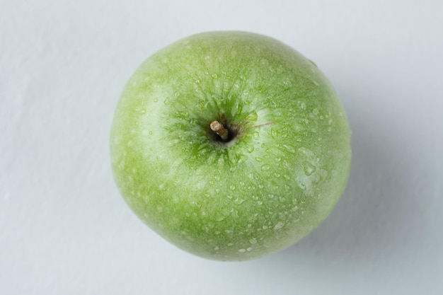 Сонгле зеленое яблоко изолированное на сером.