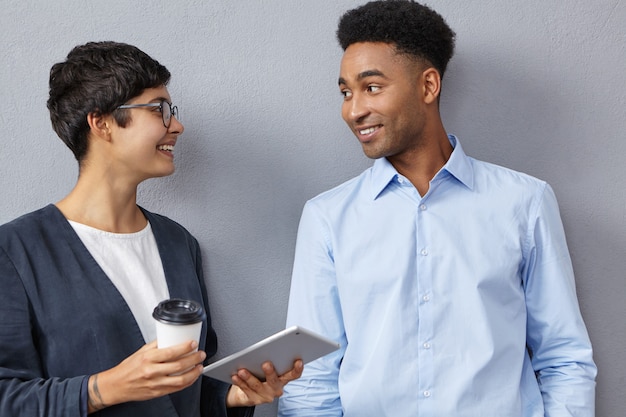 Free photo sophisticated mixed race female and male colleagues have conversation together