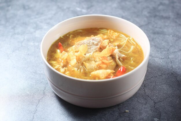Сото аям кунинг - это один из популярных индонезийских блюд в стиле желтого куриного супа. Premium Фотографии