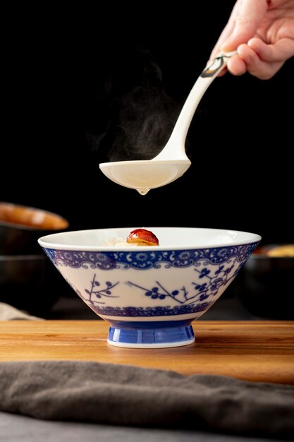 Soup jar on a wooden support and a spoon