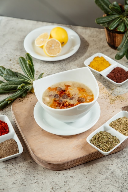 Soup served with different spices and herbs