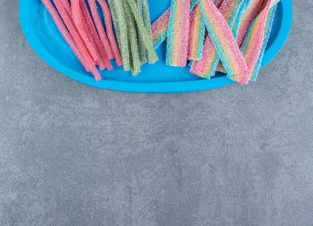 Sour chewy candies on blue plate.  