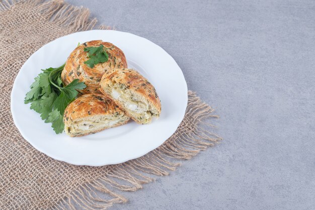 Sour gogals served on a platter with parsley garnish on marble table.