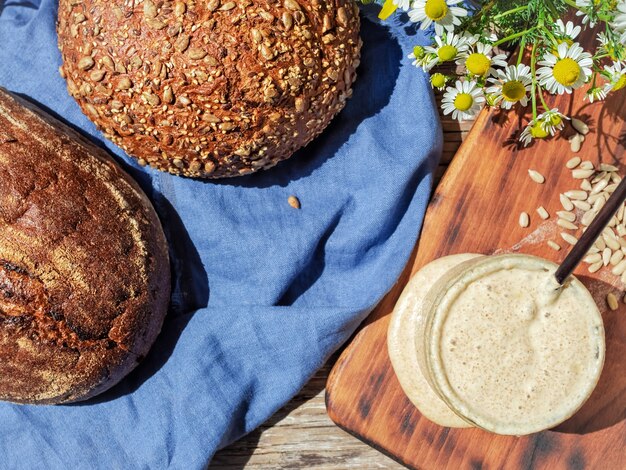 Sourdough for bread in a glass jar and homemade breads