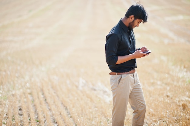 Agricoltore agronomo dell'asia meridionale che ispeziona l'azienda agricola del campo di grano concetto di produzione agricola