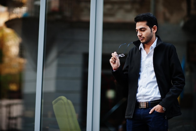 South asian indian male student wear eyeglasses and casual posed outdoor