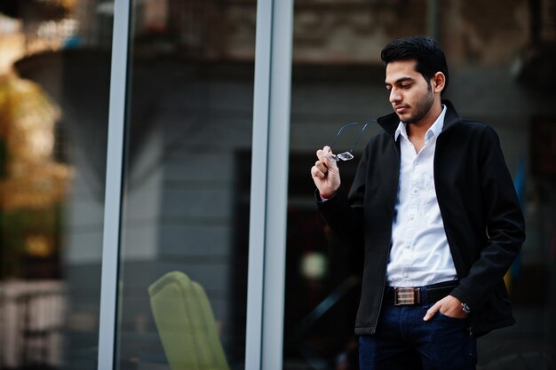 South asian indian male student wear eyeglasses and casual posed outdoor