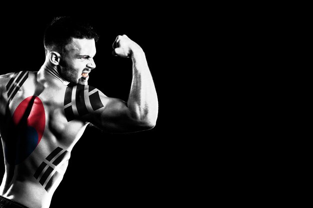 South Korea flag on handsome young muscular man black background