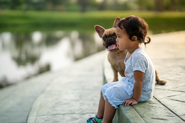 Free photo southeast asian cute baby girl with her adorable french bulldog