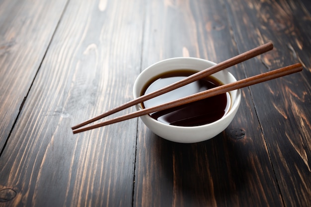 Soy sauce and soy bean on wooden table.