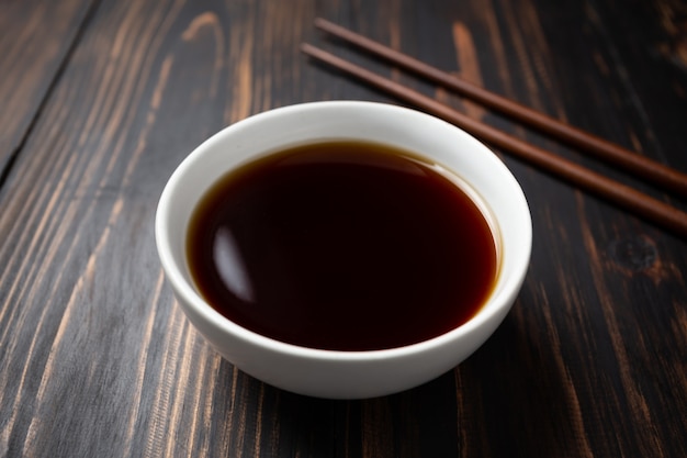 Soy sauce and soy bean on wooden table.