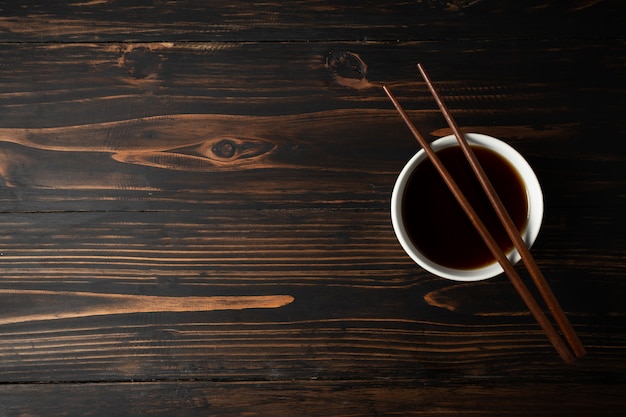 Soy sauce and soy bean on wooden table.