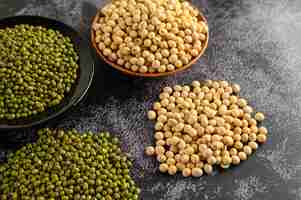 Free photo soybean and mung bean on a black cement floor.