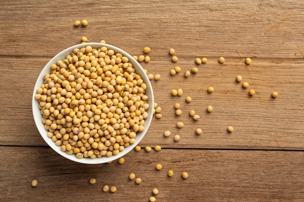 Soybean seeds on wooden floor and hemp sacks Food nutrition concept.