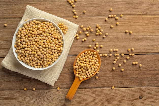 Soybean Seeds On Wooden Floor And Hemp Sacks Food Nutrition Concept.