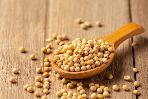 Soybean seeds on wooden floor and hemp sacks Food nutrition concept.