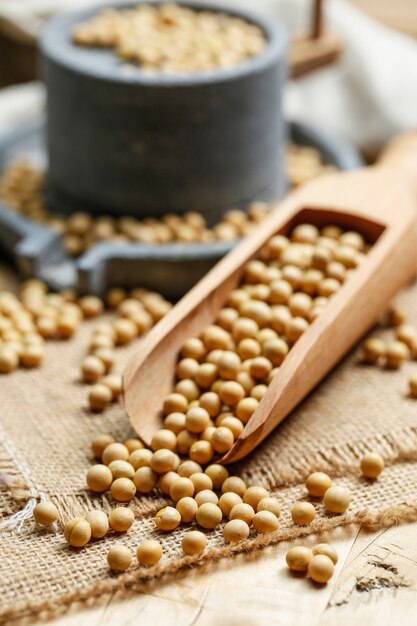 Soybeans in wooden scoop and a little stone mill