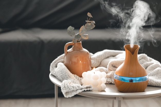 Free photo spa composition with aroma oil diffuser lamp and candle on a blurred background