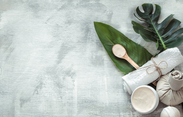 Spa composition with body care items on a light wall.