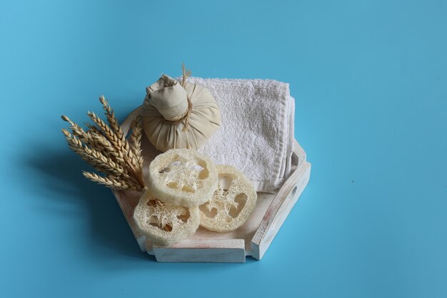 Spa composition with herbal bag loofah and wheat on a blue background