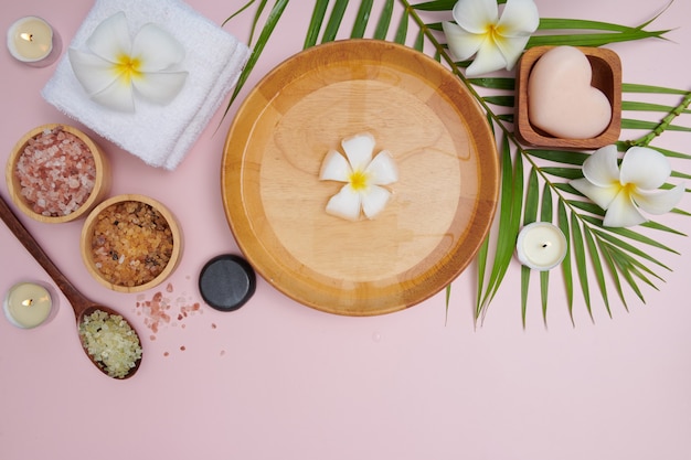 Spa concept. Beauty and fashion concept with spa set. perfumed flowers water. Relaxation and zen, Spa setting flat lay with bowl, bath salt and flowers, towel and natural soap. top view.